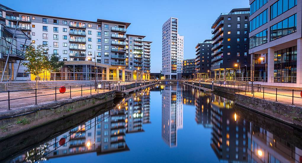 Illuminated waterfront apartments and skyline reflections at Leeds Dock, prime location for a Leeds stag do.