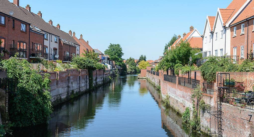 Waterfront townhouses along the River Wensum at Friars Quay, picturesque riverside location for a Norwich stag do.